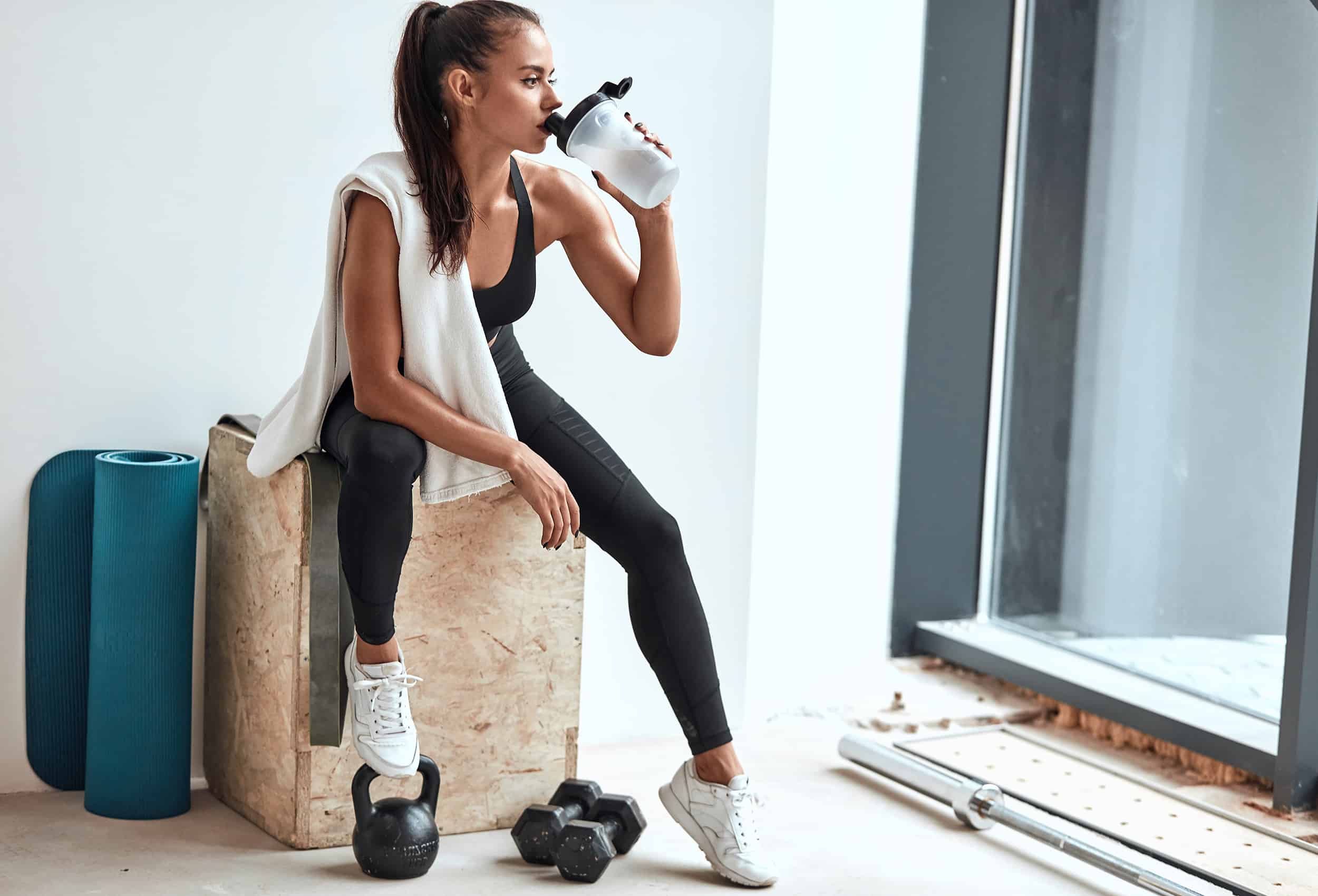 woman-taking-a-workout-break-drinking-water