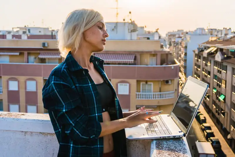 woman-on-rooftop-writing-affirmations-on-apple-laptop