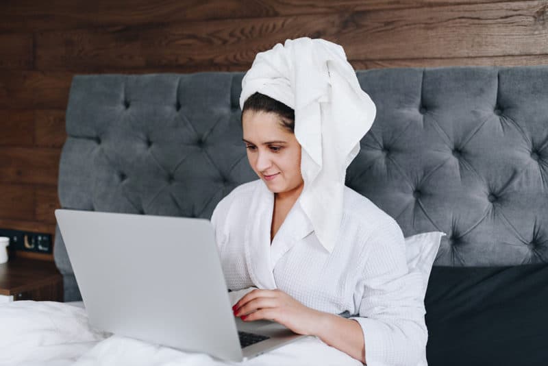 woman-sitting-on-bed-with-towel-morning-routine-writing-affirmations