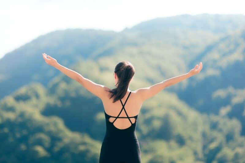 woman-assuming-desire-is-done-hands-in-the-air-embracing-nature