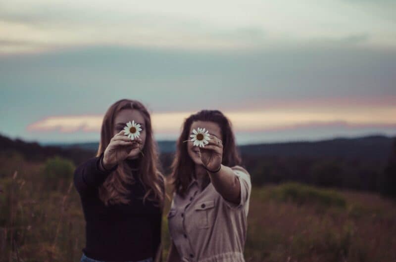 two-woman-holding-daisy-flowers-in-nature