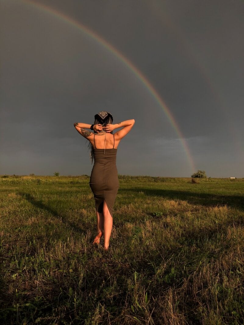 woman-in-black-dress-walking-in-nature-rainbow-vibration