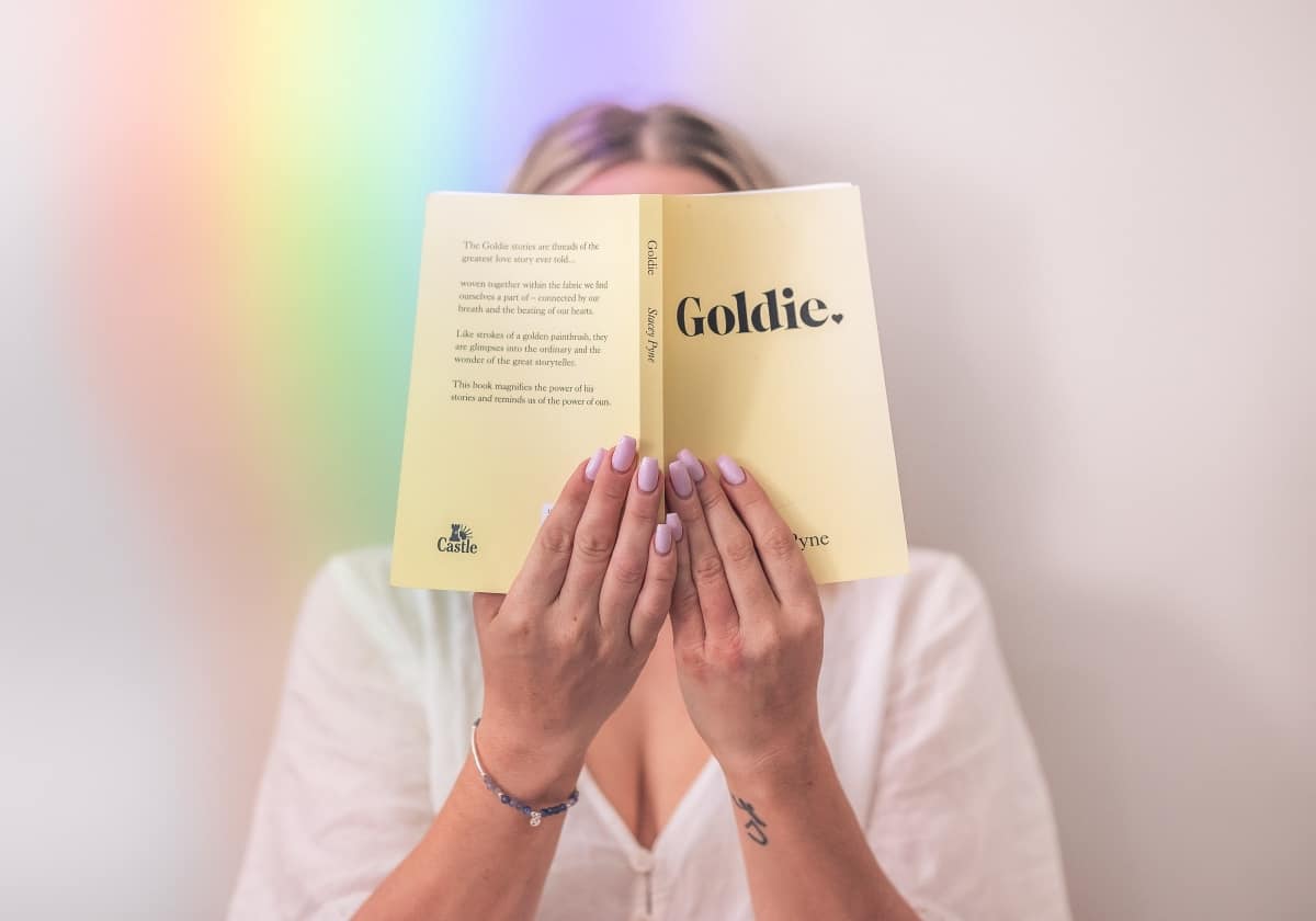 woman-rainbow-vibration-holding-goldie-book