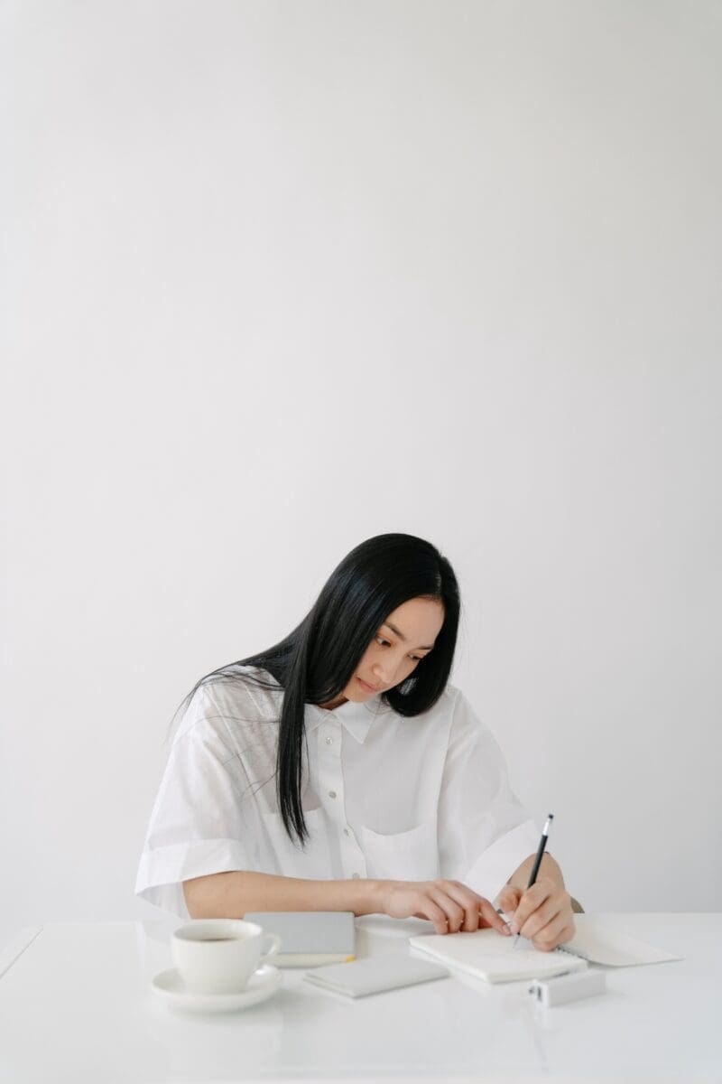 asian-woman-white-long-black-hair-writing-in-journal