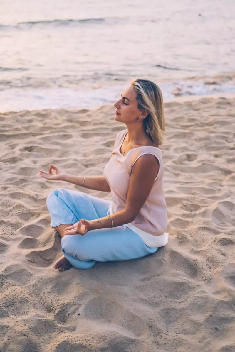 woman-wearing-pink-meditating-connecting-to-intuition-onn-beach