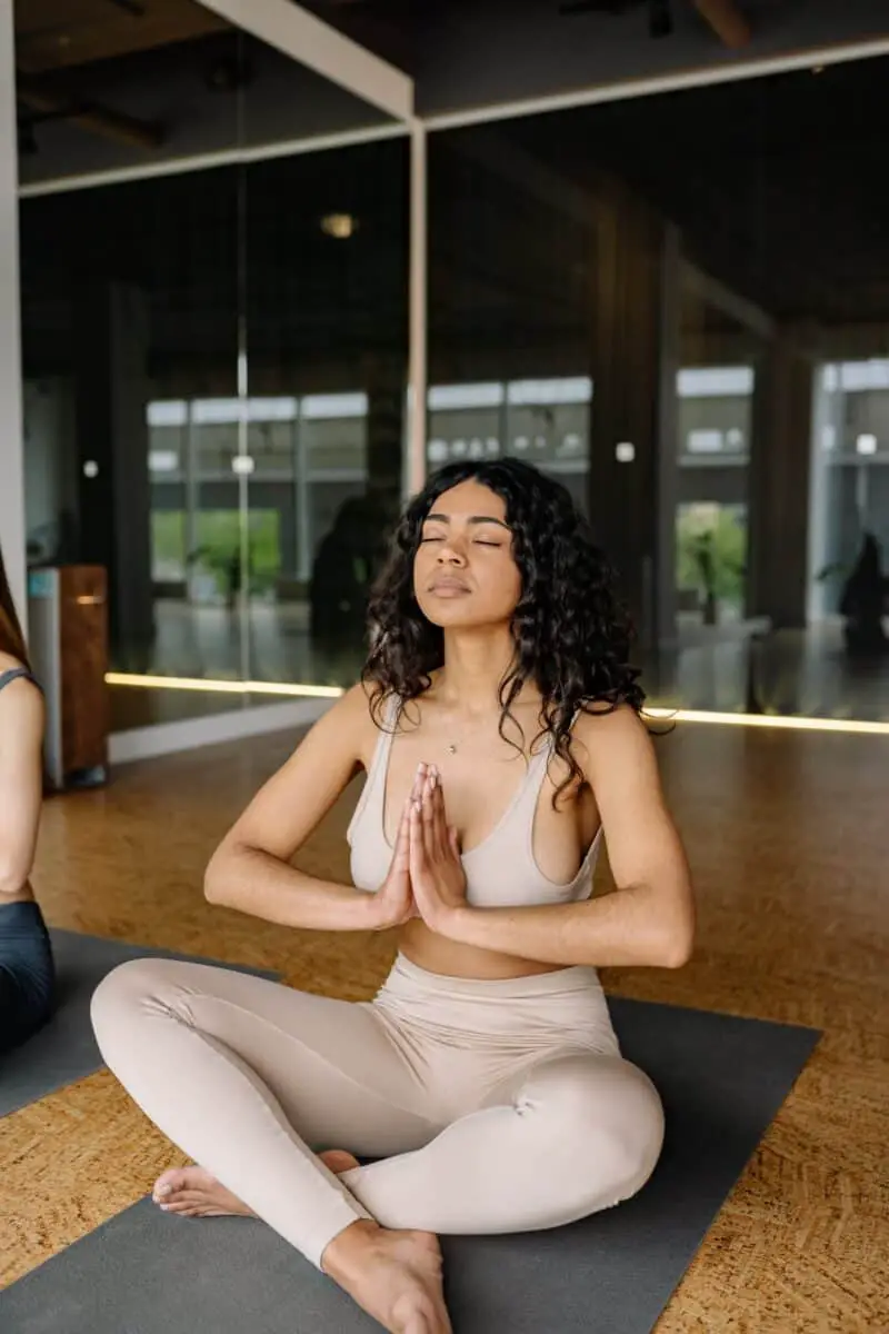 woman-with-curly-hair-in-yoga-clothes-praying