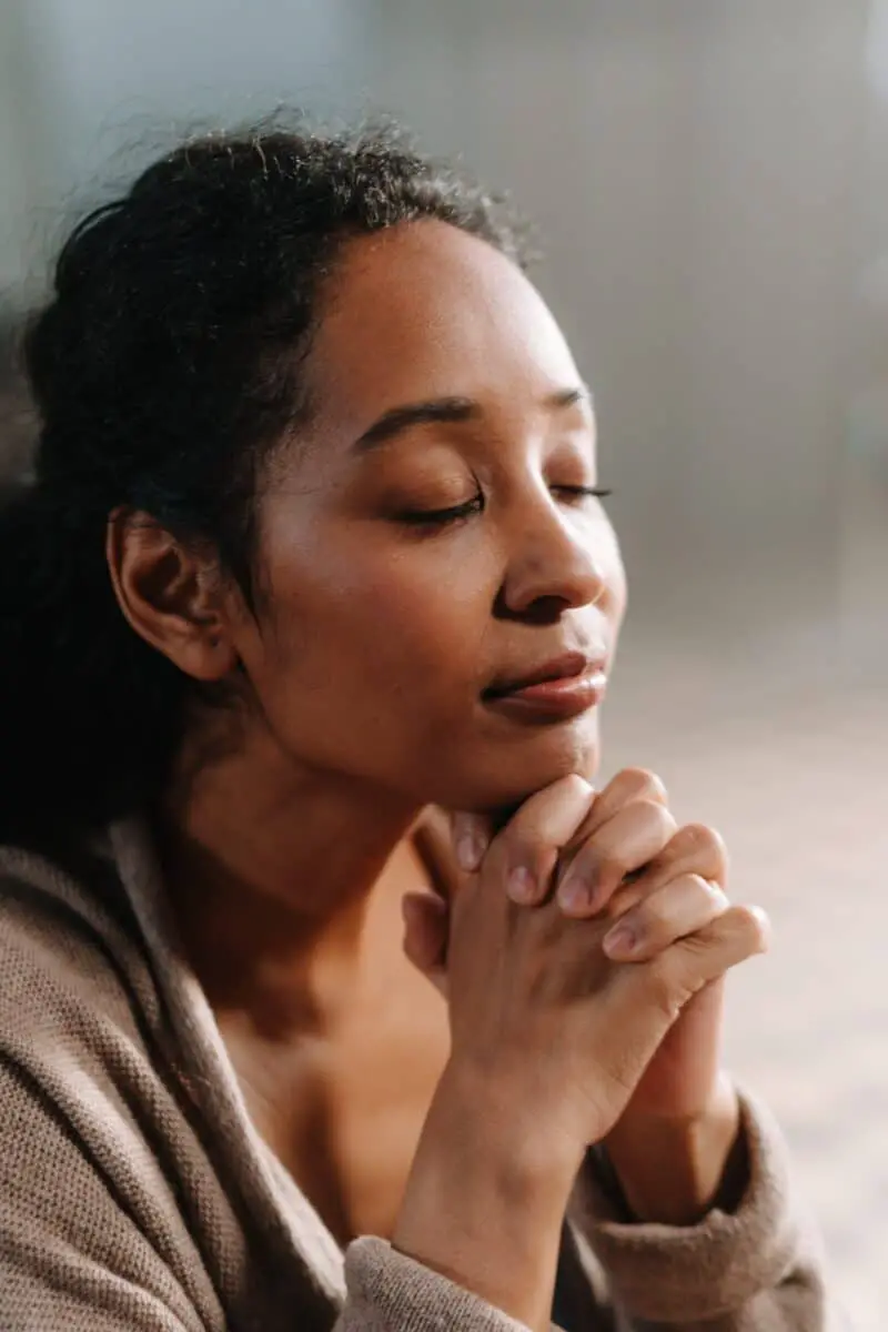 woman-with-curly-hair-tied-praying