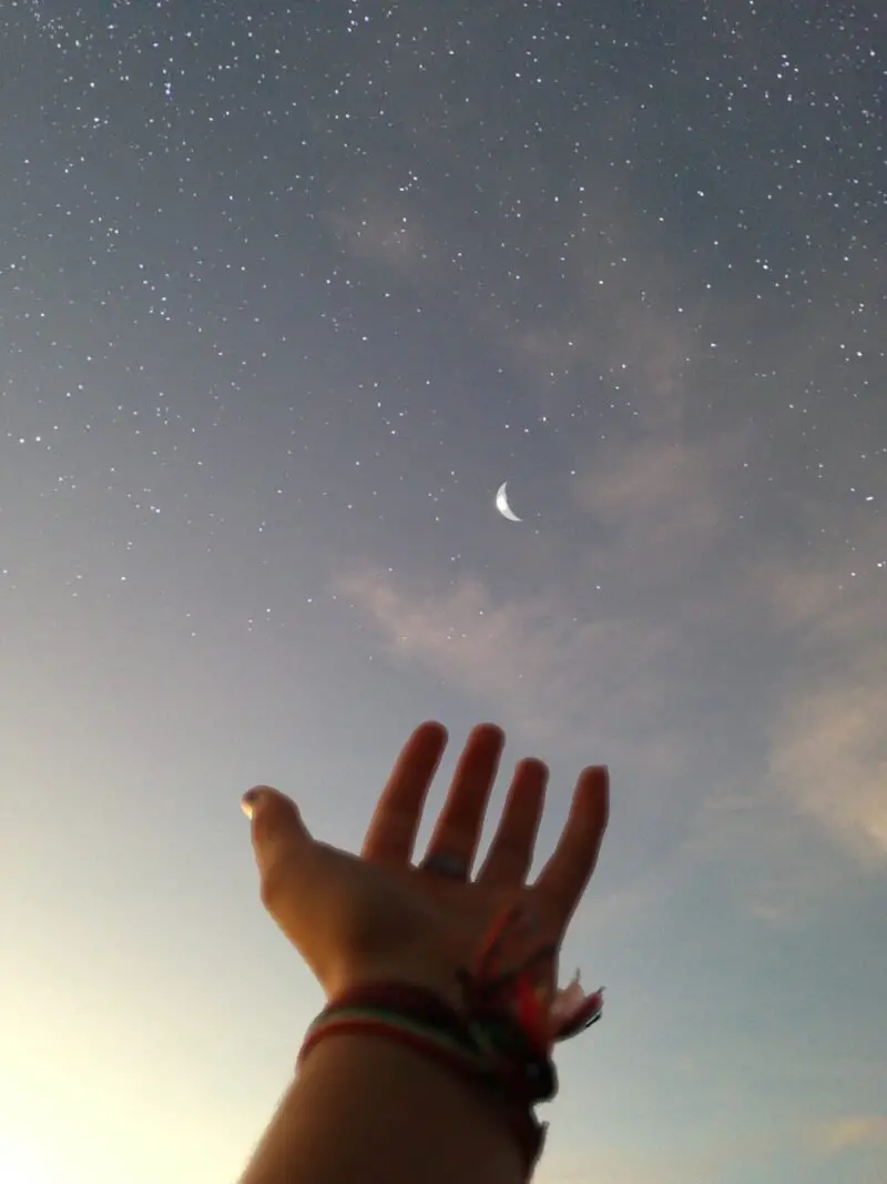 hand-reaching-out-to-sky-stars-crescent-moon