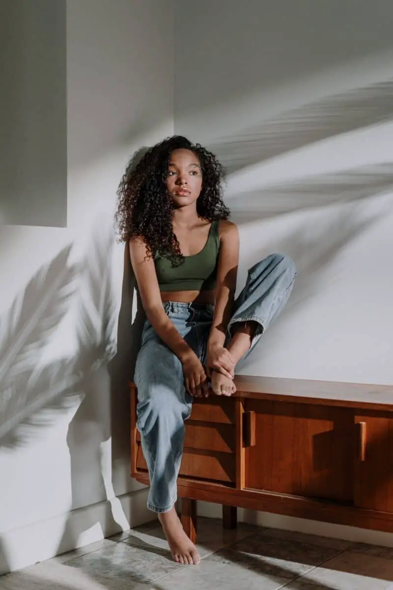 african-woman-with-curly-hair-sitting-on-tv-stand-shadow