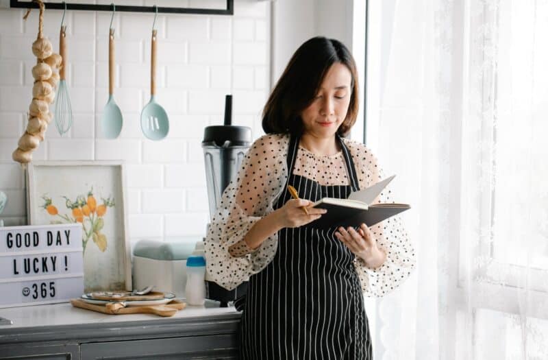 asian-woman-wearing-apron-writing food-recipes-journal