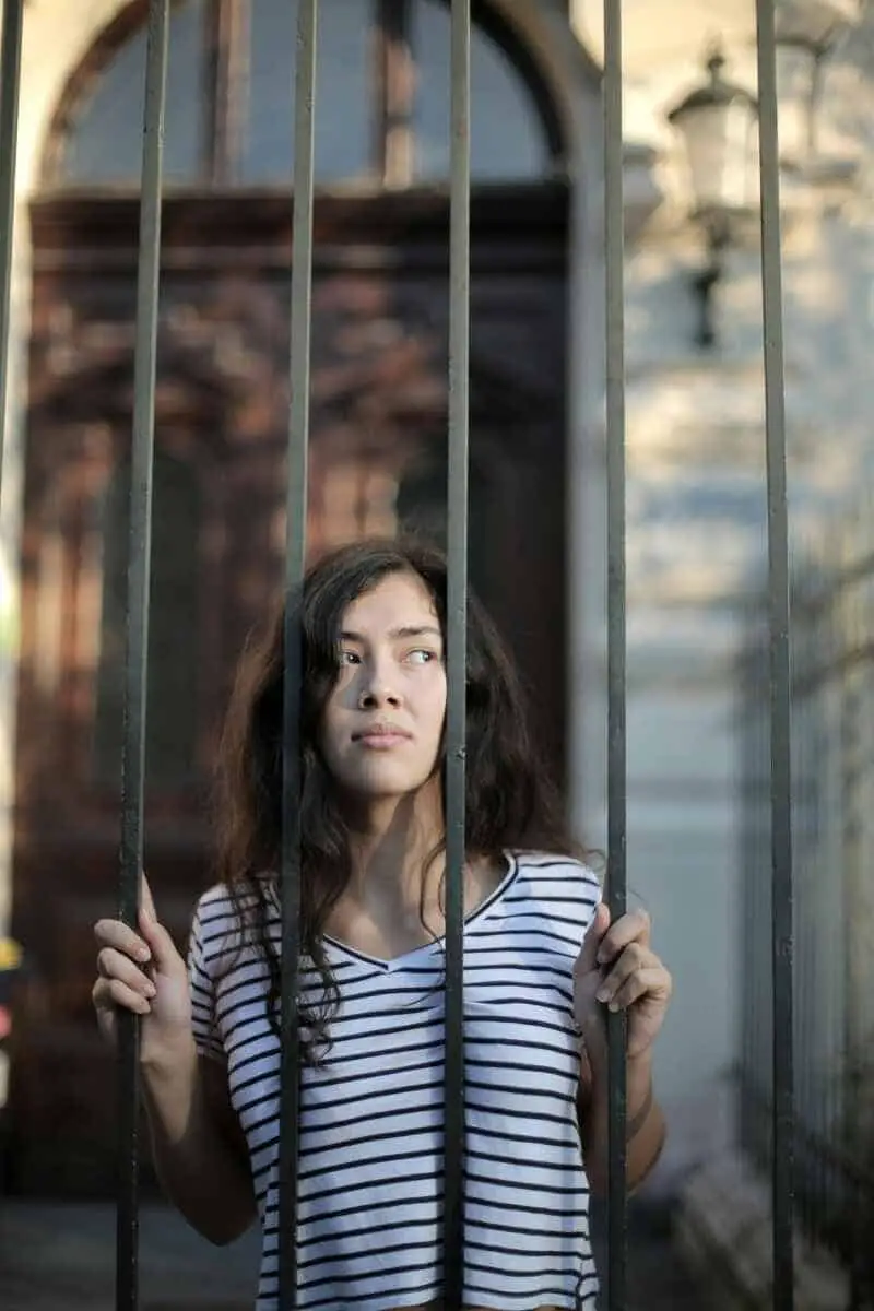 how-to-identify-limiting-beliefs-asian-girl-with-curly-hair-behind-gates-fence