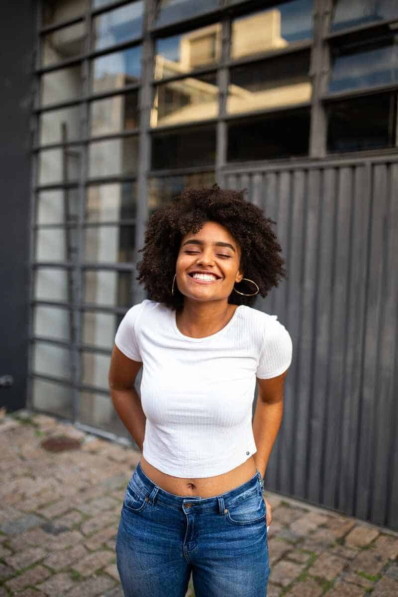 sign-manifestation-is-close-African-woman-wearing-blue-jeans-white-shirt-smiling-happy