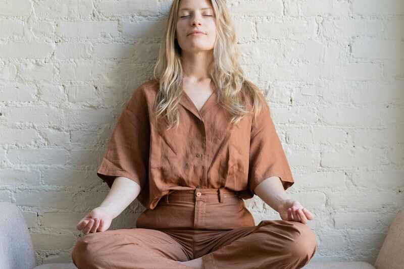 woman-in-taupe-jumpsuit-meditating-overcoming-limiting-beliefs