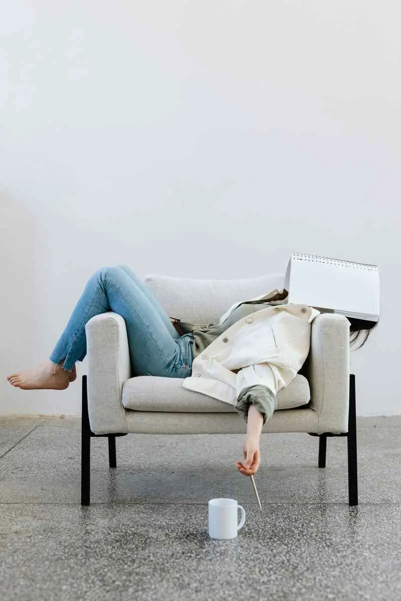 woman-laying-in-chair-with-notebook-tired-of-limiting-beliefs